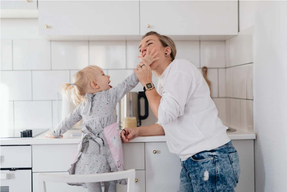 Mom and daughter in kitchen sharing a calm moment together, symbolizing nervous system regulation, and finding calm in the chaos of motherhood.